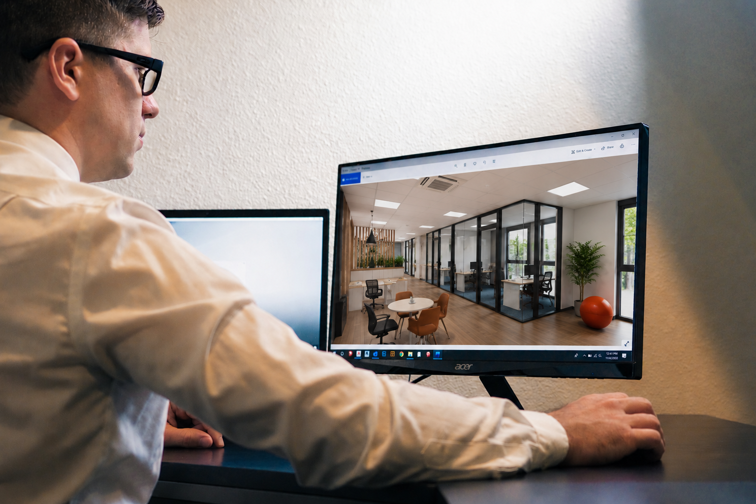 Concepteur travaillant sur un visuel 3D d'aménagement de bureaux à l'écran